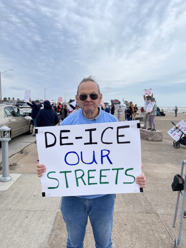 Richard Davis at the Ice Out For Good protest, holding a sign that reads "DE-ICE OUR STREETS"